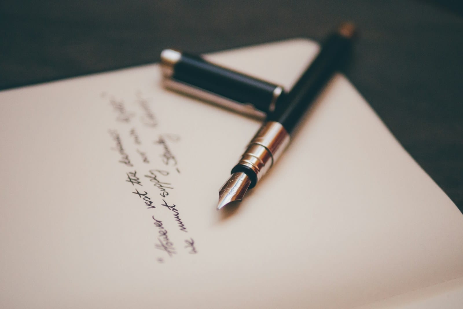 A fountain pen resting on blank stationery.