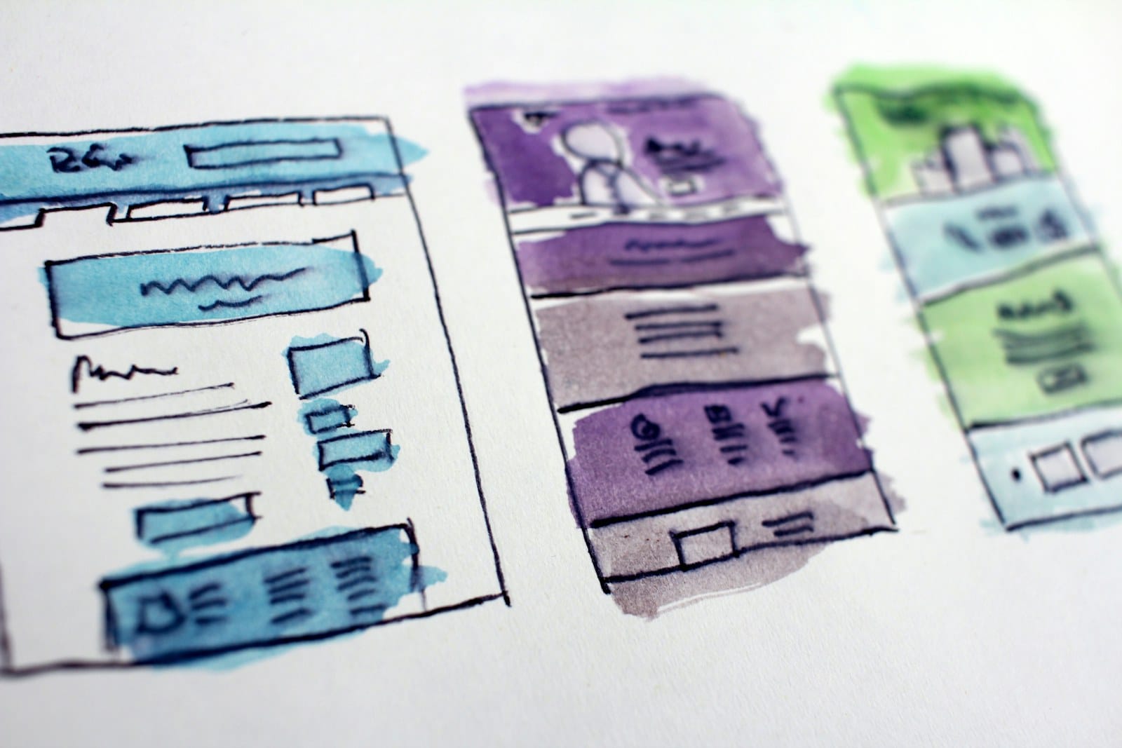 Hand-drawn wireframe sketches of website layouts on paper.