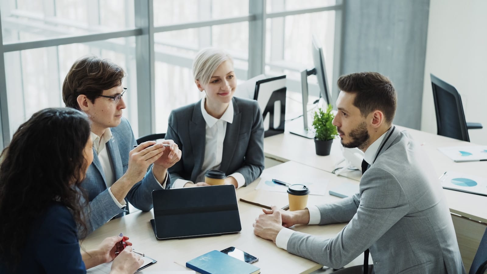 A team of professionals in a strategy meeting, representing B2B demand generation built around pipeline.