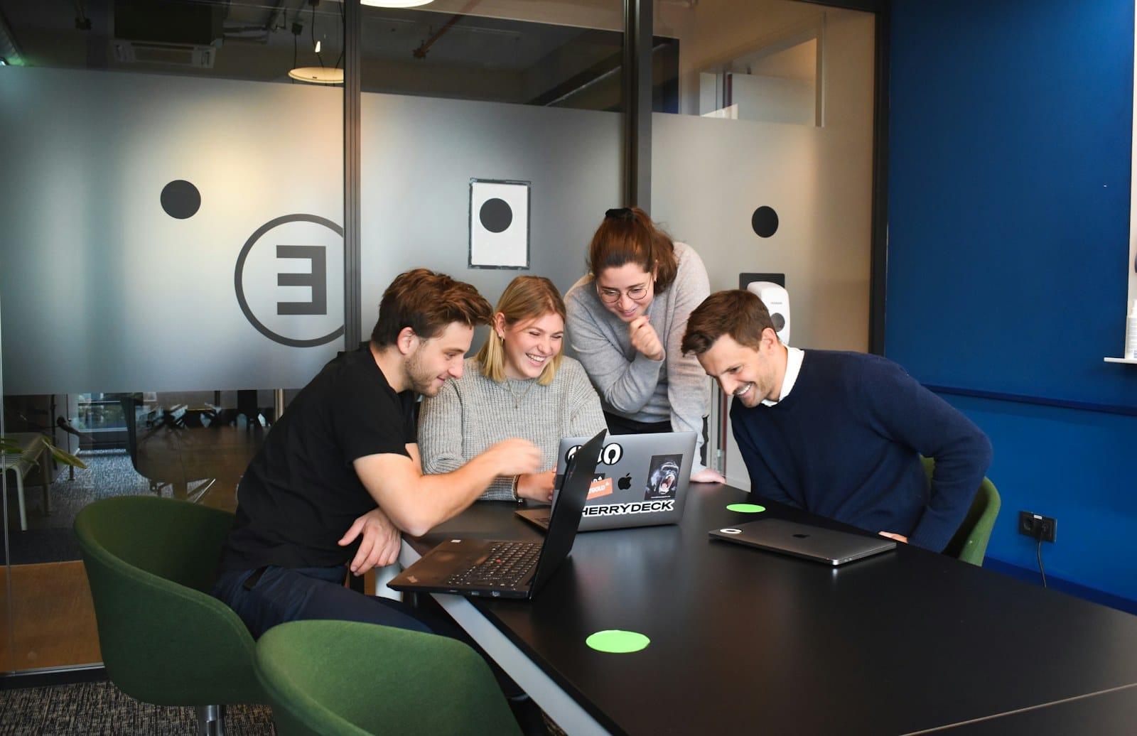 Colleagues coordinating around laptops.