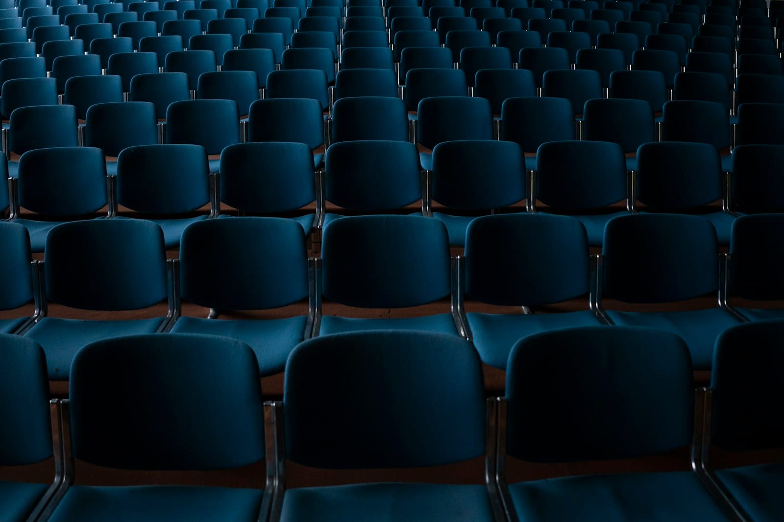 Rows of empty navy conference-hall seats, the audience a trade association is not yet reaching.