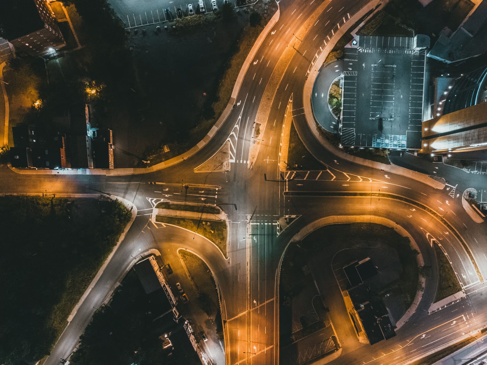 A road junction seen from directly above at night, its lanes drawn in light.