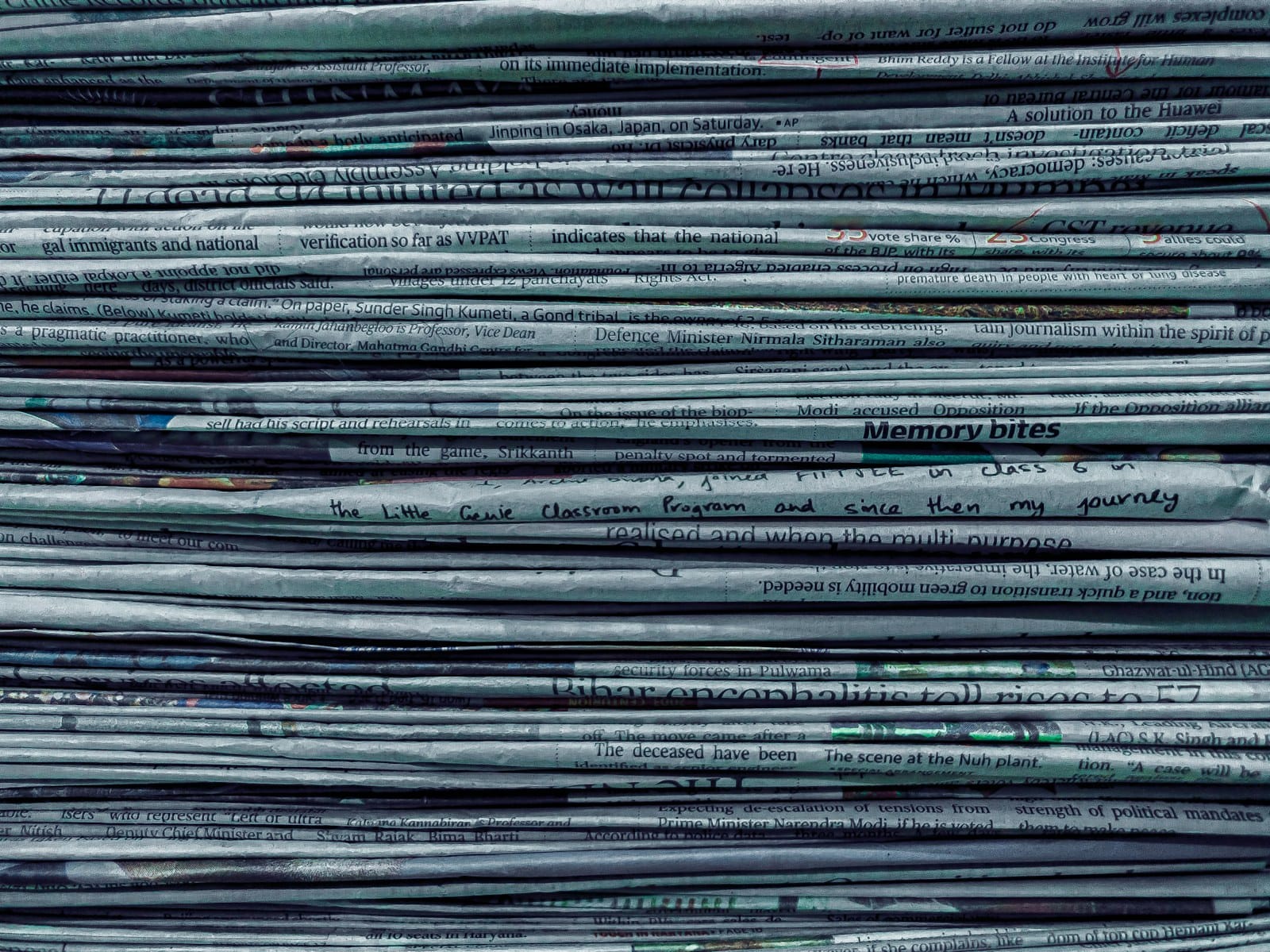 A stack of printed newspapers with prominent headlines.