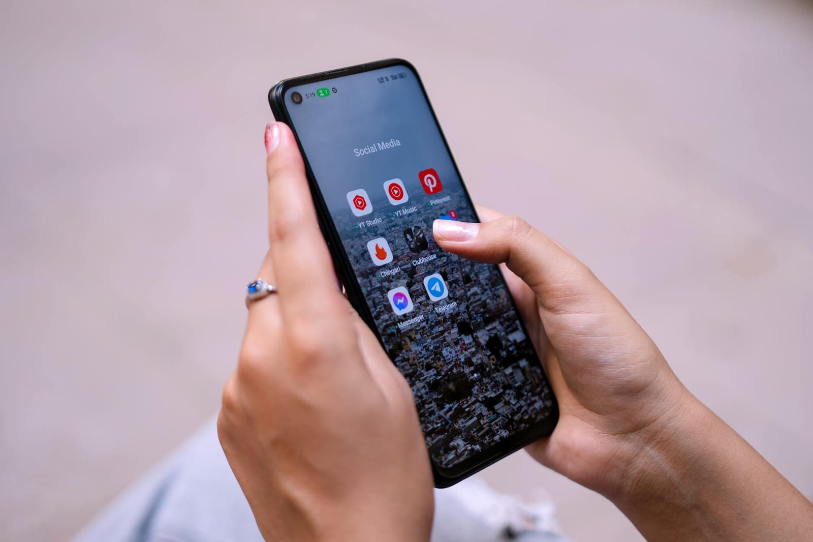 A hand holding a phone open on social apps.