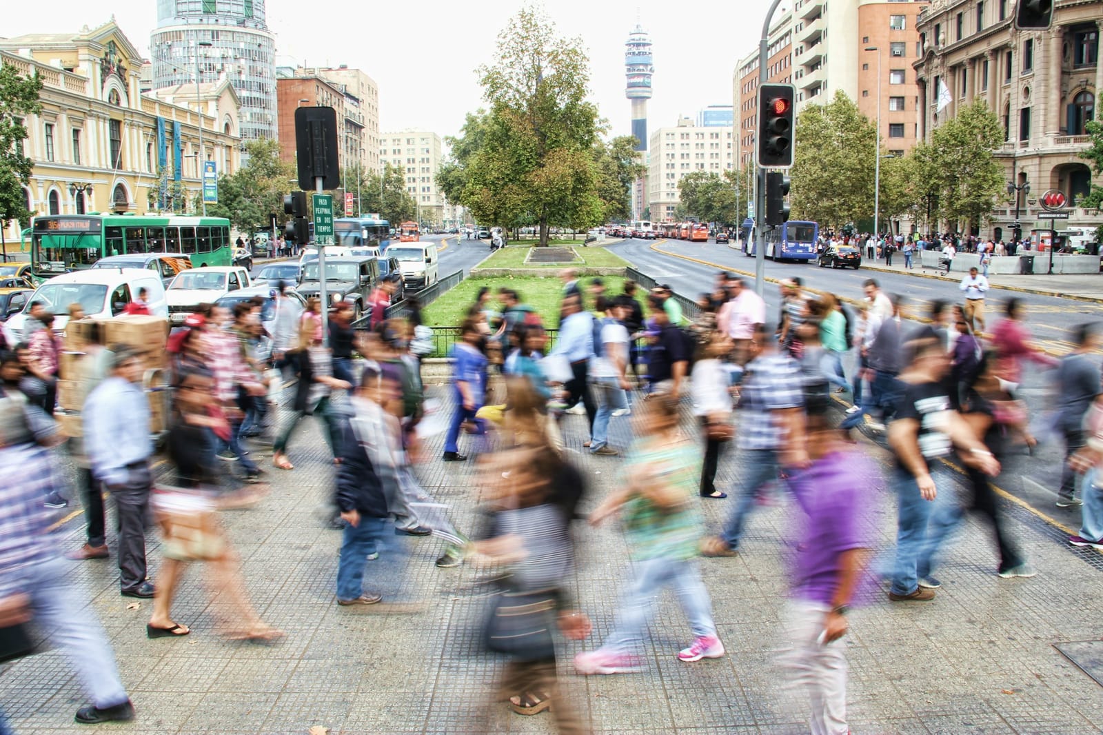 A crowd of pedestrians crossing a city street, caught in motion blur.